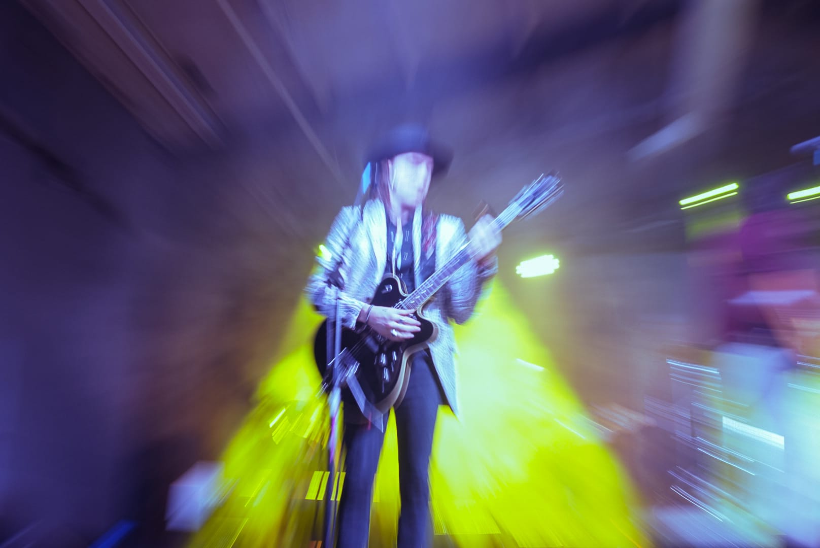 Zoom-blur shot of a guitarist under yellow light, May 2 live recording