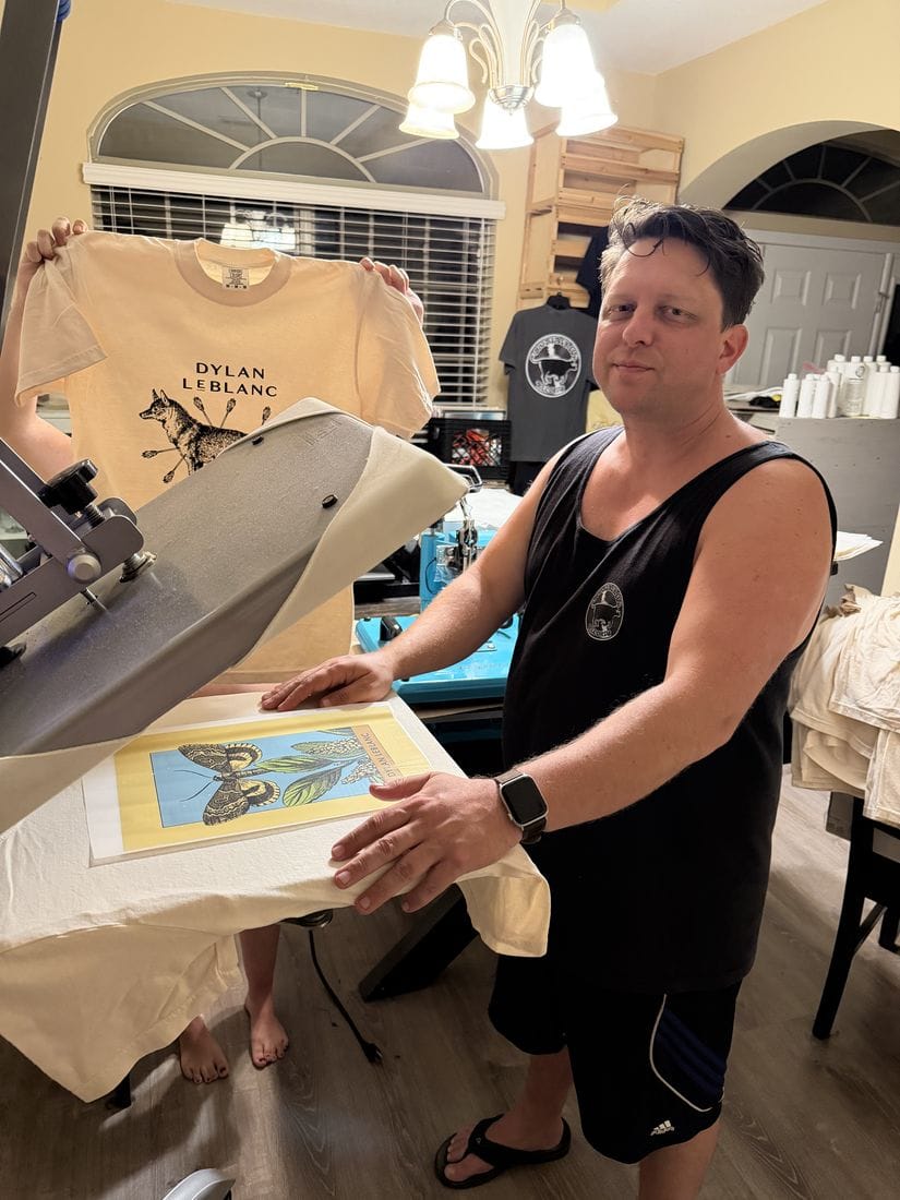 BBCR merchandise production at a heat press with Dylan LeBlanc moth artwork.
