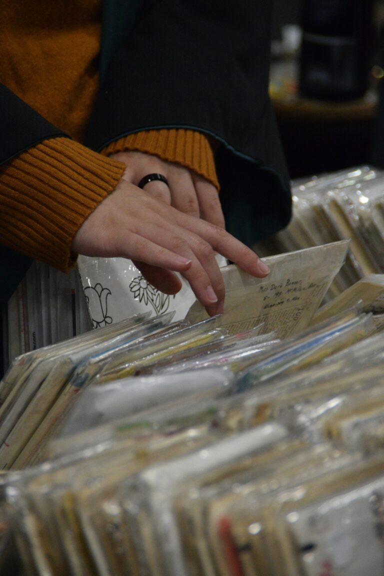 Hands digging through a crate of used vinyl records
